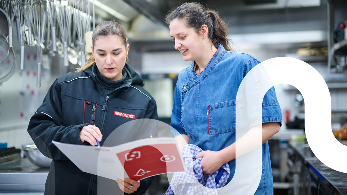 Eine Mitarbeiterin von REMONDIS berät eine Kundin aus einer Restaurantküche zu ihrem Fettabscheider.