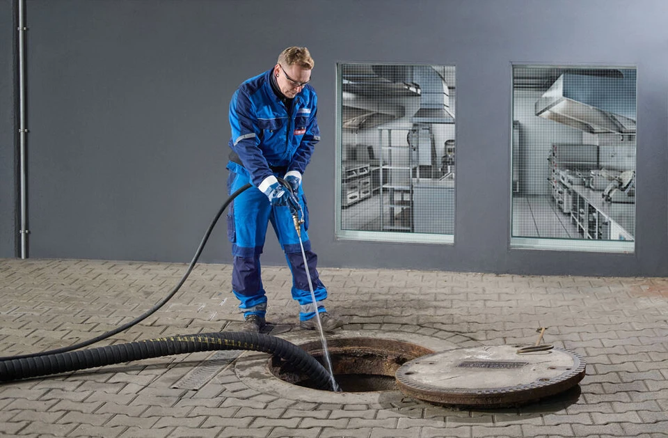 Remondis Mitarbeiter arbeitet mit Hochdruck-Reiniger am Fettabscheider